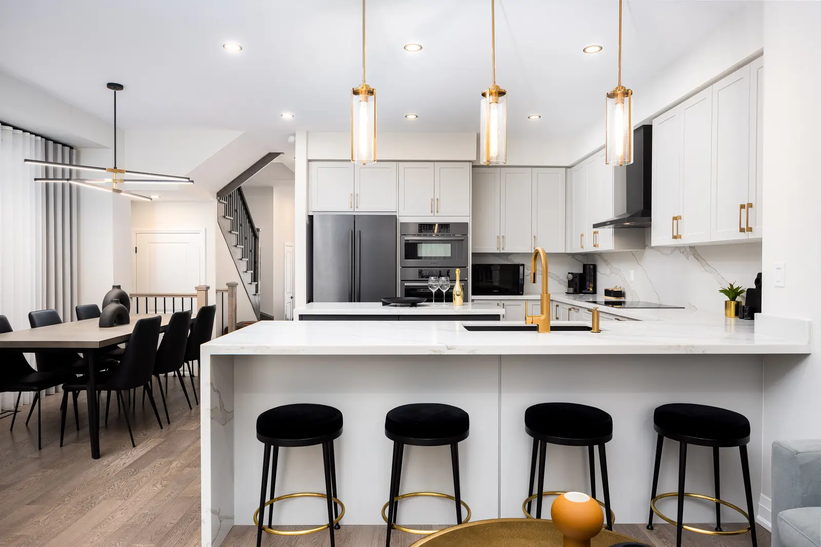 Kitchen island in a Richmond Hill townhouse, with black stools looking toward the dining table