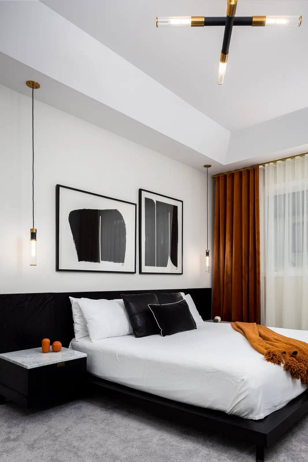 Bedroom in a Richmond Hill townhouse, with a black bed, a gold ceiling light, and mustard curtains