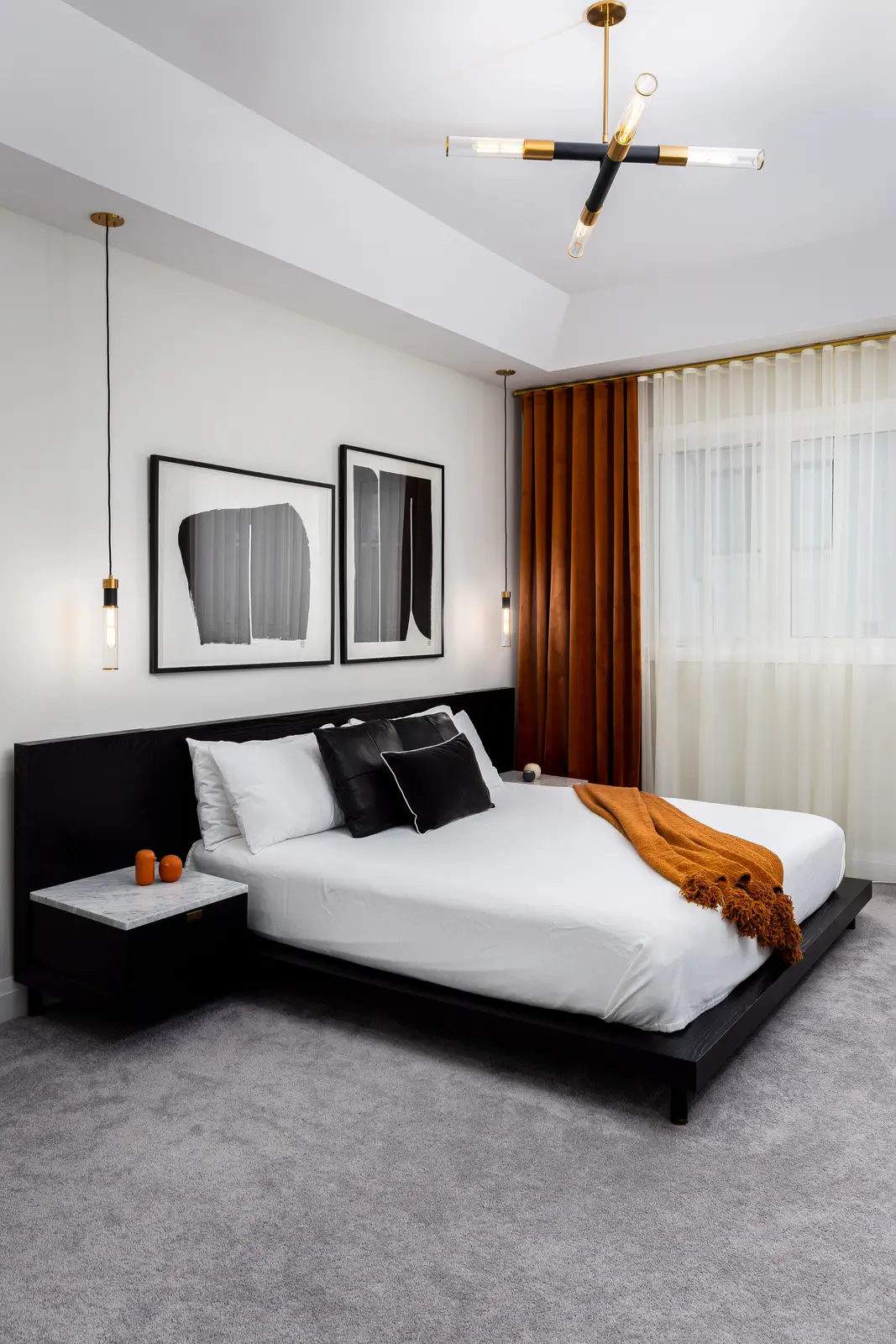 Bedroom in a Richmond Hill townhouse, with a black bed and a gold ceiling light