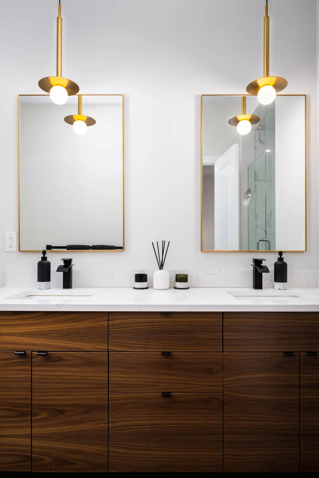 Walnut double vanity in a Richmond Hill townhouse, with a white marble counter, black faucets, and gold-framed mirrors