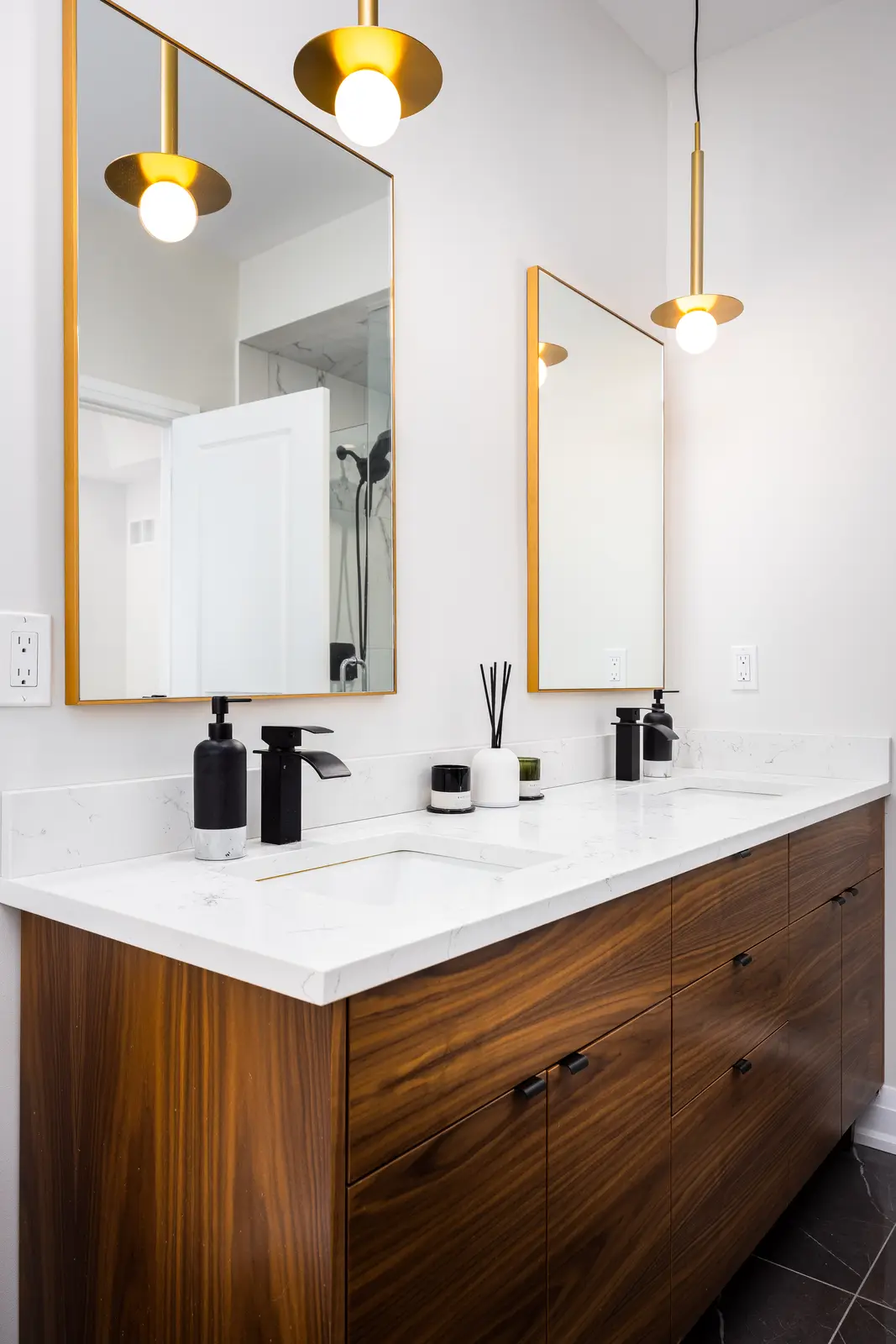 Walnut double vanity in a Richmond Hill townhouse, with gold pendants and gold-framed mirrors