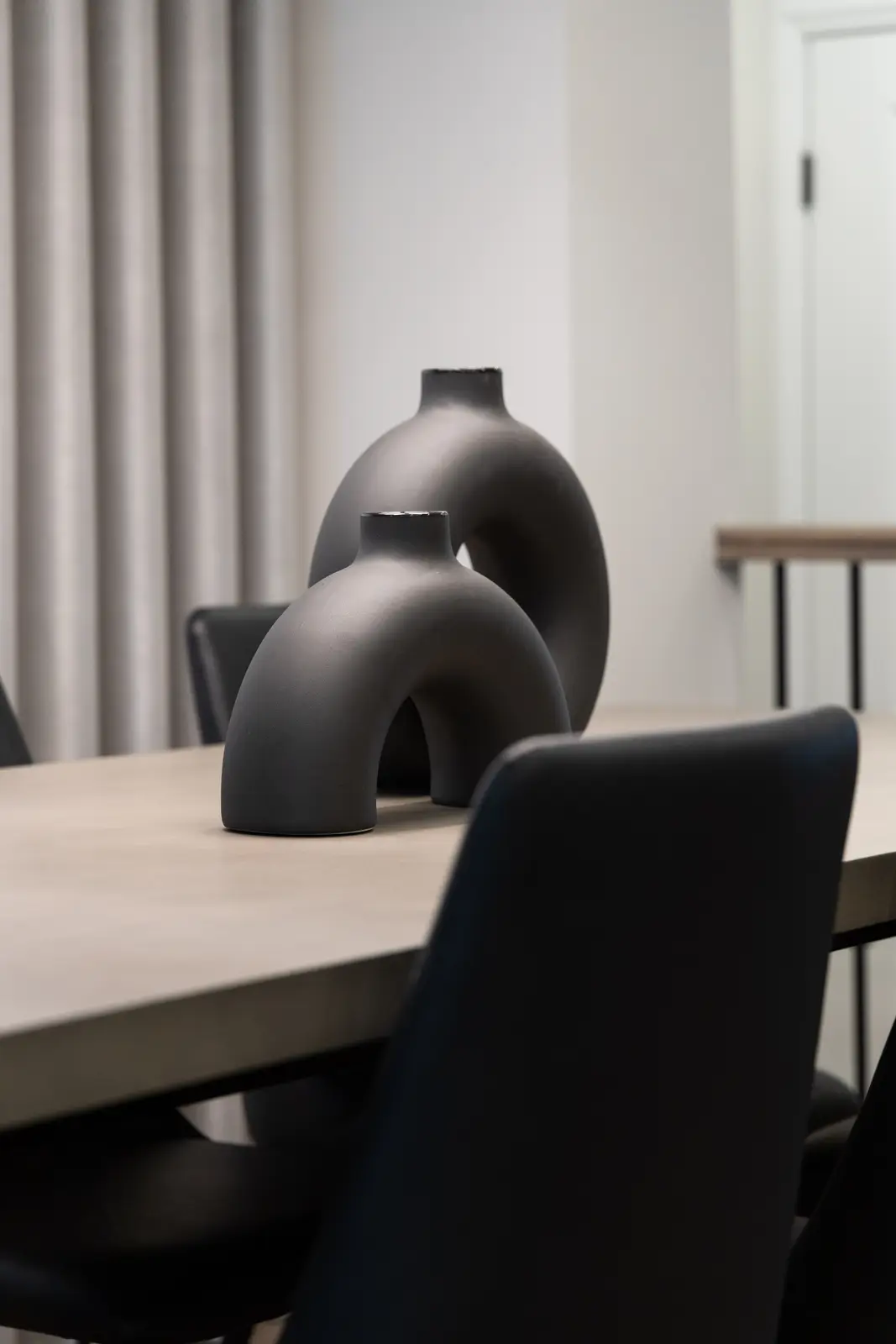 Dining table in a Richmond Hill townhouse, with black chairs and a dark vase