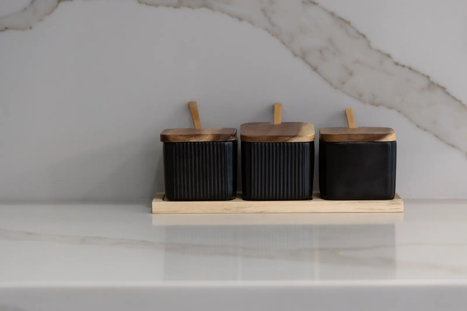 Black canisters on a marble kitchen counter in a Richmond Hill townhouse