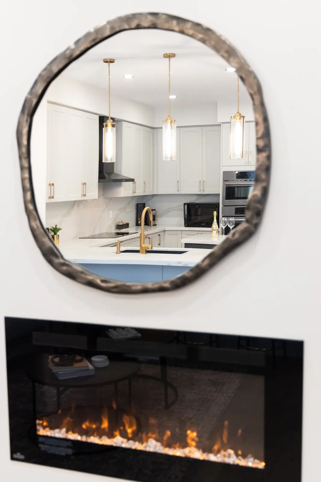 Round mirror above the linear fireplace in a Richmond Hill townhouse living room