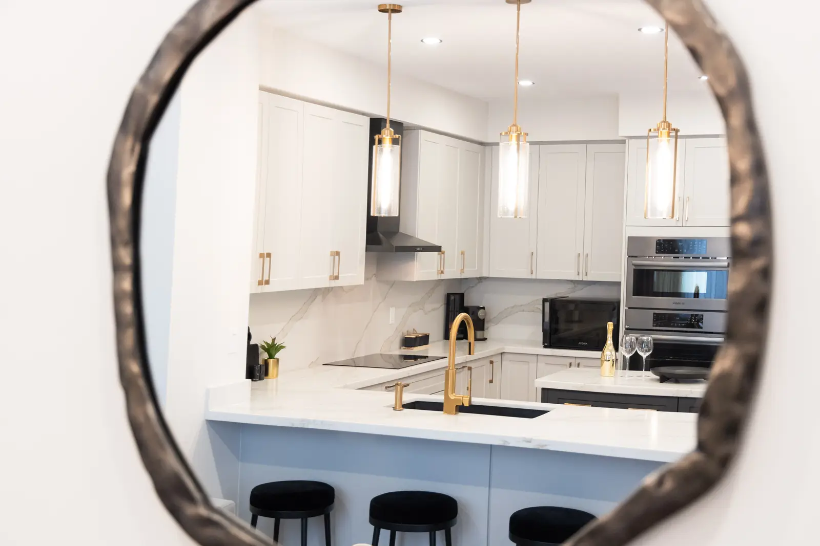Kitchen reflected in the round living room mirror of a Richmond Hill townhouse