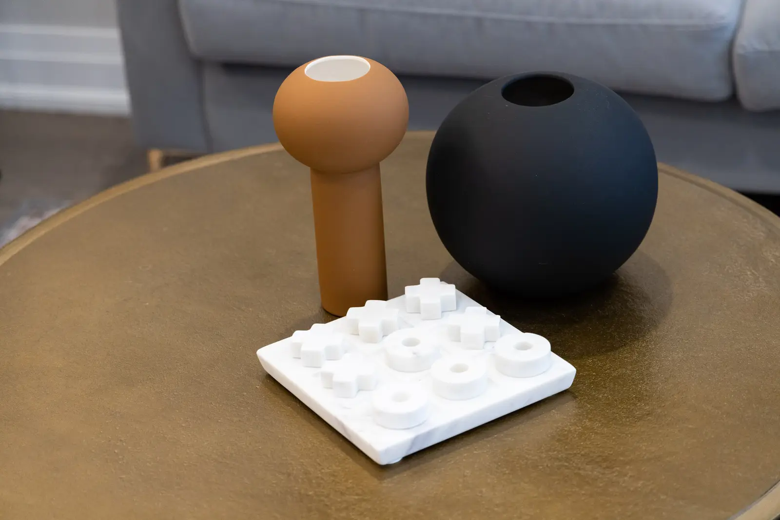 Coffee table in a Richmond Hill townhouse living room, with ceramic vessels beside the grey sofa