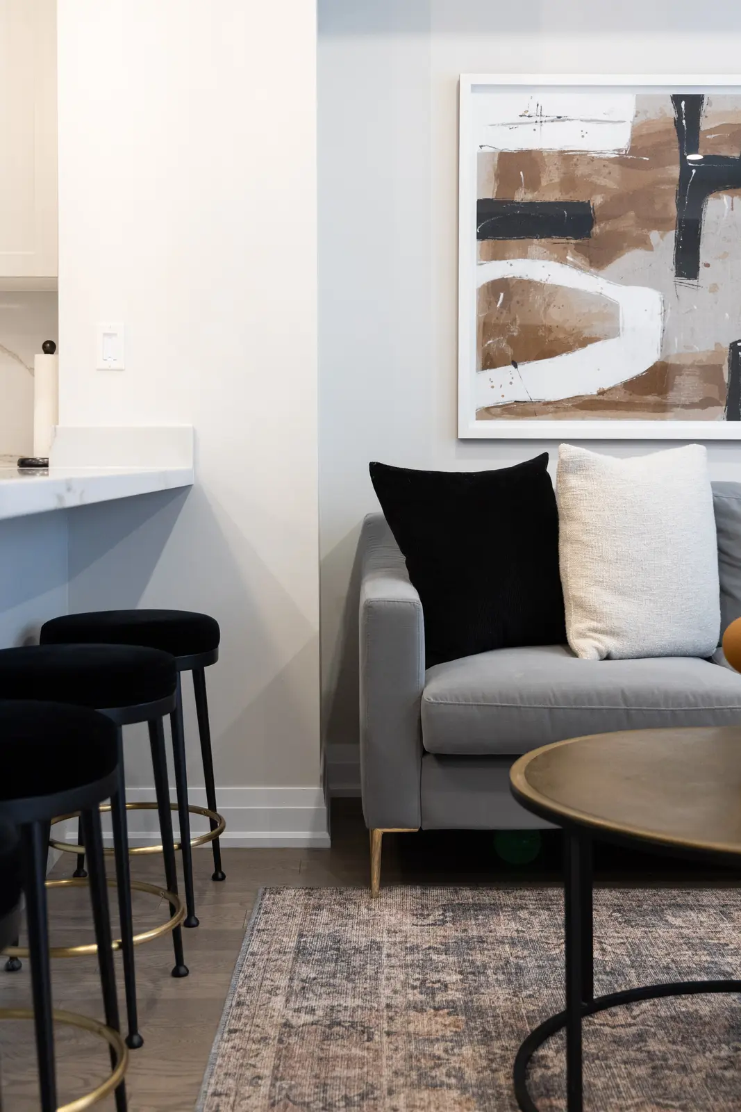 Grey sofa and black stools at the marble island in a Richmond Hill townhouse