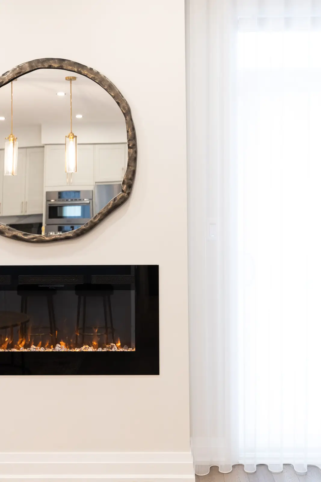 Linear fireplace and round mirror in the living room of a Richmond Hill townhouse