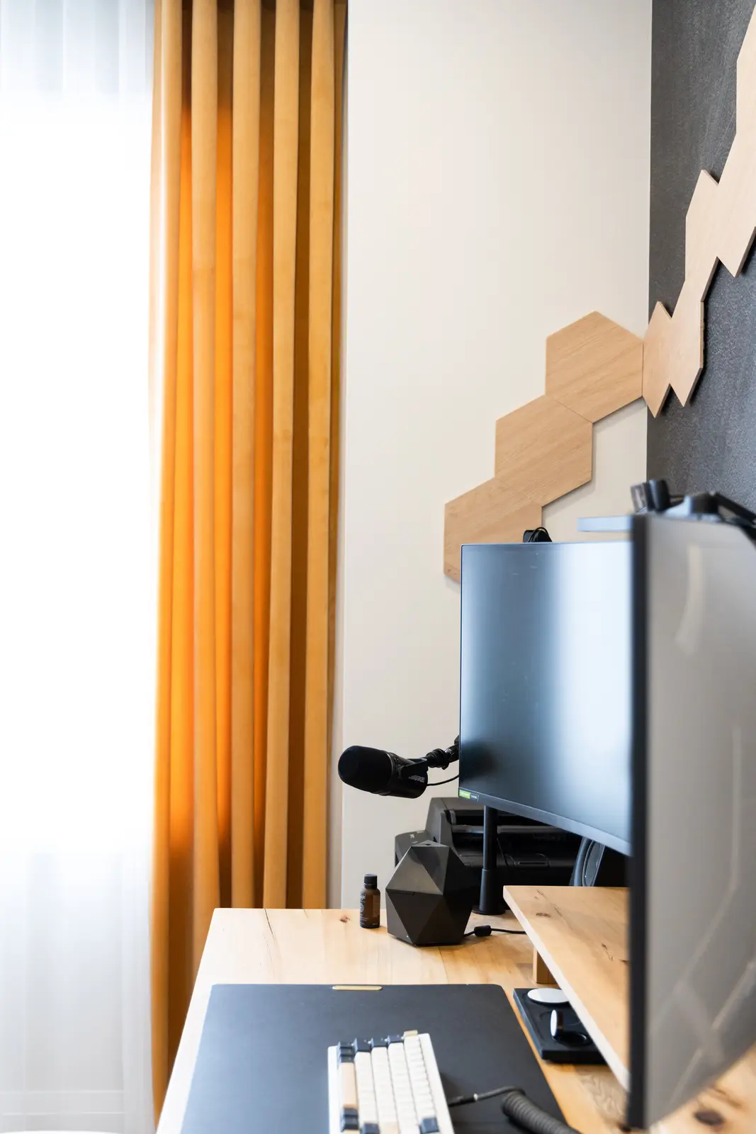 Office desk in a Richmond Hill townhouse, beside mustard curtains and hexagonal lights