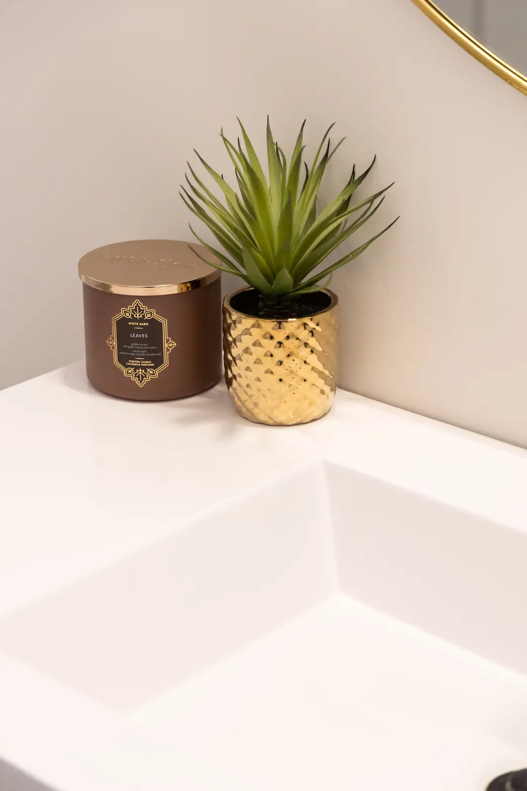 Marble bathroom counter in a Richmond Hill townhouse, with a gold planter and a candle