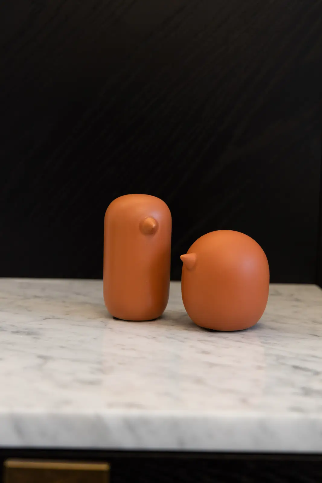 Two terracotta vessels on a marble nightstand in a Richmond Hill townhouse bedroom