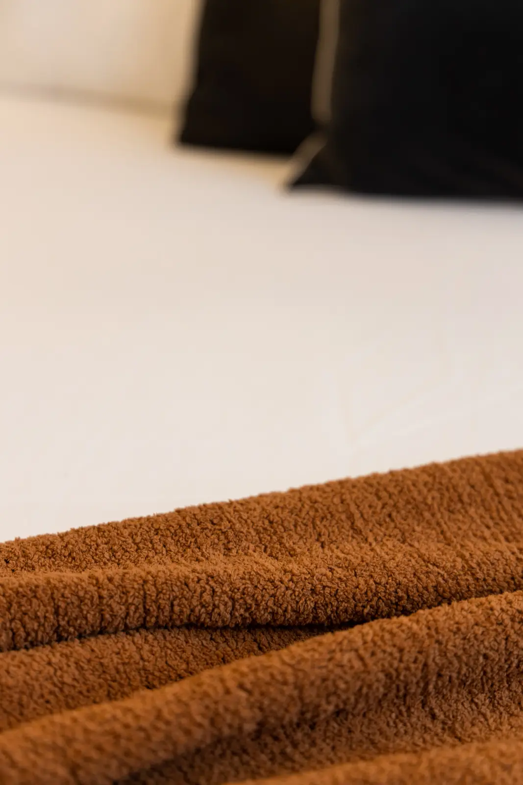 Brown throw on the white bed in a Richmond Hill townhouse