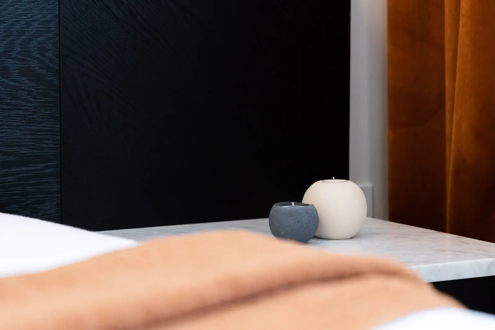 Marble nightstand with candles beside the black headboard in a Richmond Hill townhouse