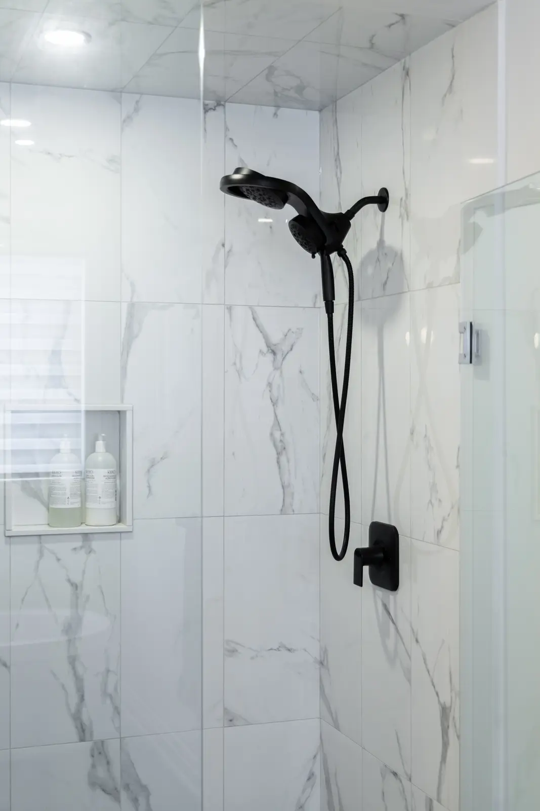 Marble shower with a black shower head in a Richmond Hill townhouse
