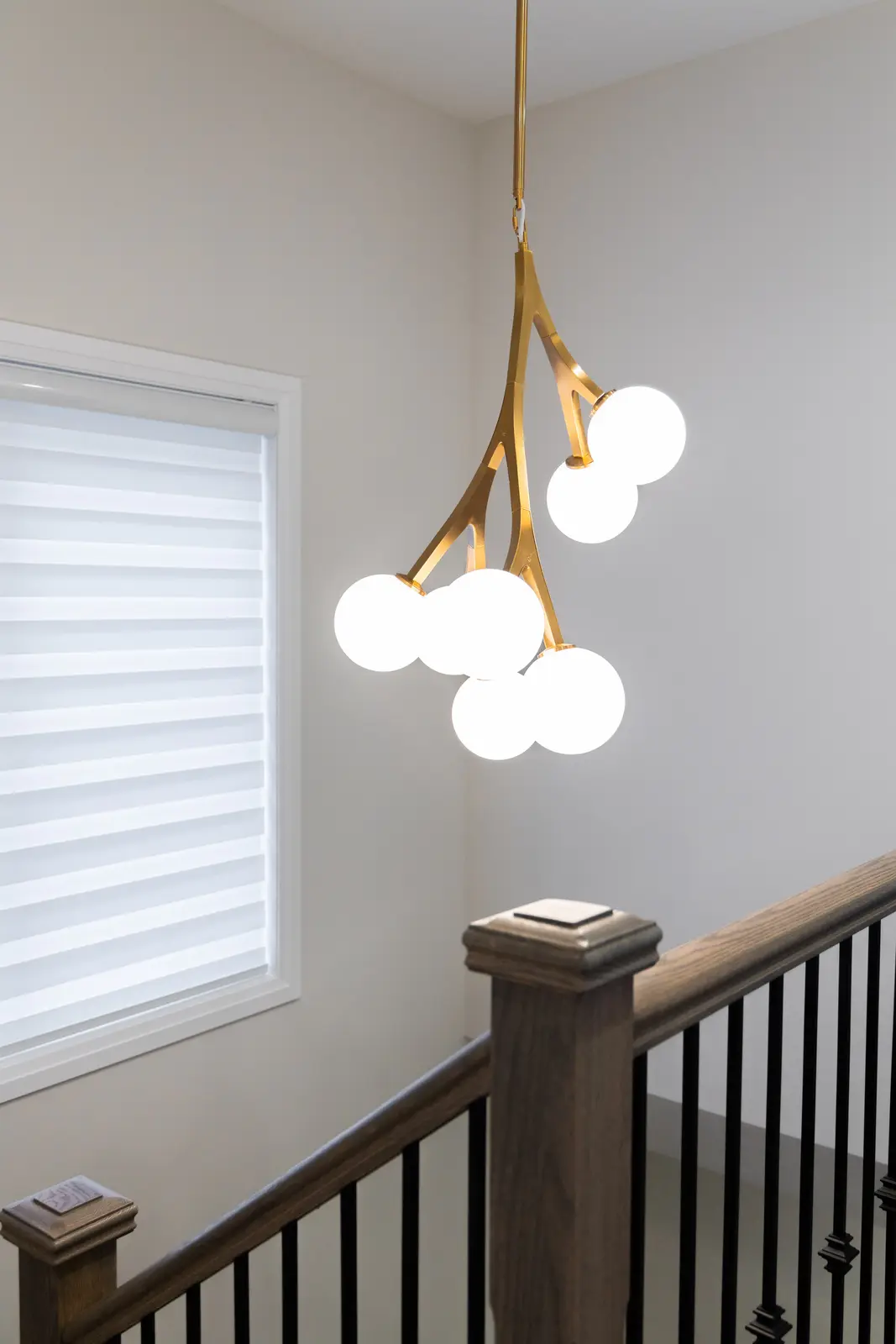 Gold branch chandelier and the stair railing in a Richmond Hill townhouse