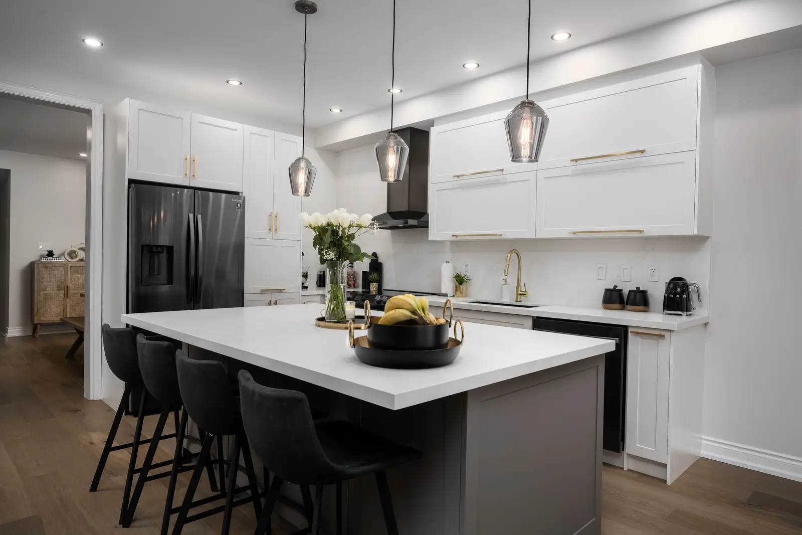 Interior of the Bristlewood Crescent renovation in Vaughan, with white cabinetry, warm wood floors, and black fittings.