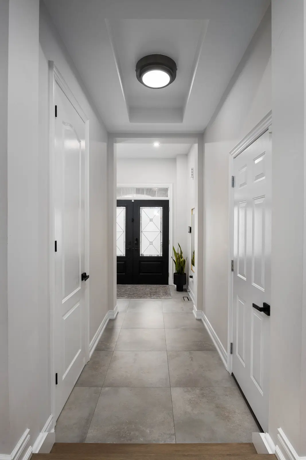 Interior of the Bristlewood Crescent renovation in Vaughan, with white cabinetry, warm wood floors, and black fittings.