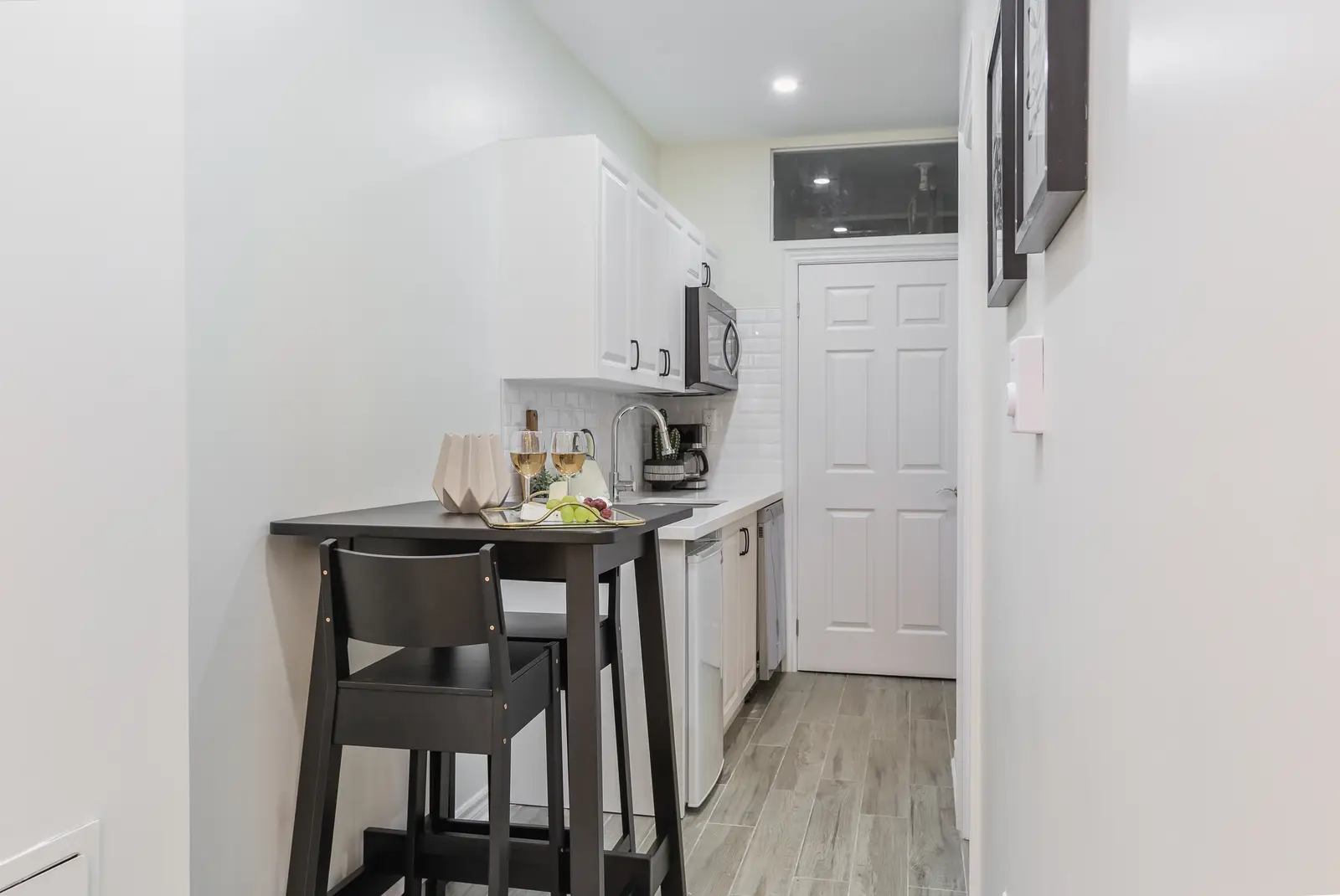 Finished room in a downtown Toronto basement renovation, with white walls, light wood floors, and grey upholstery.