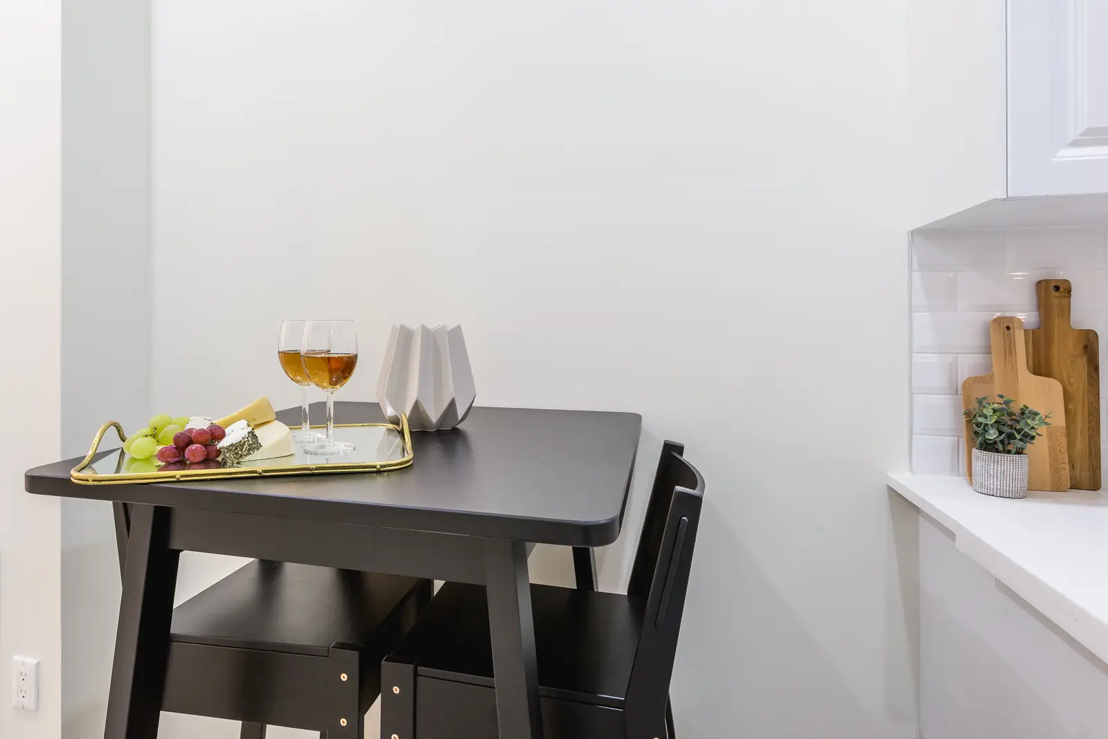 Finished room in a downtown Toronto basement renovation, with white walls, light wood floors, and grey upholstery.