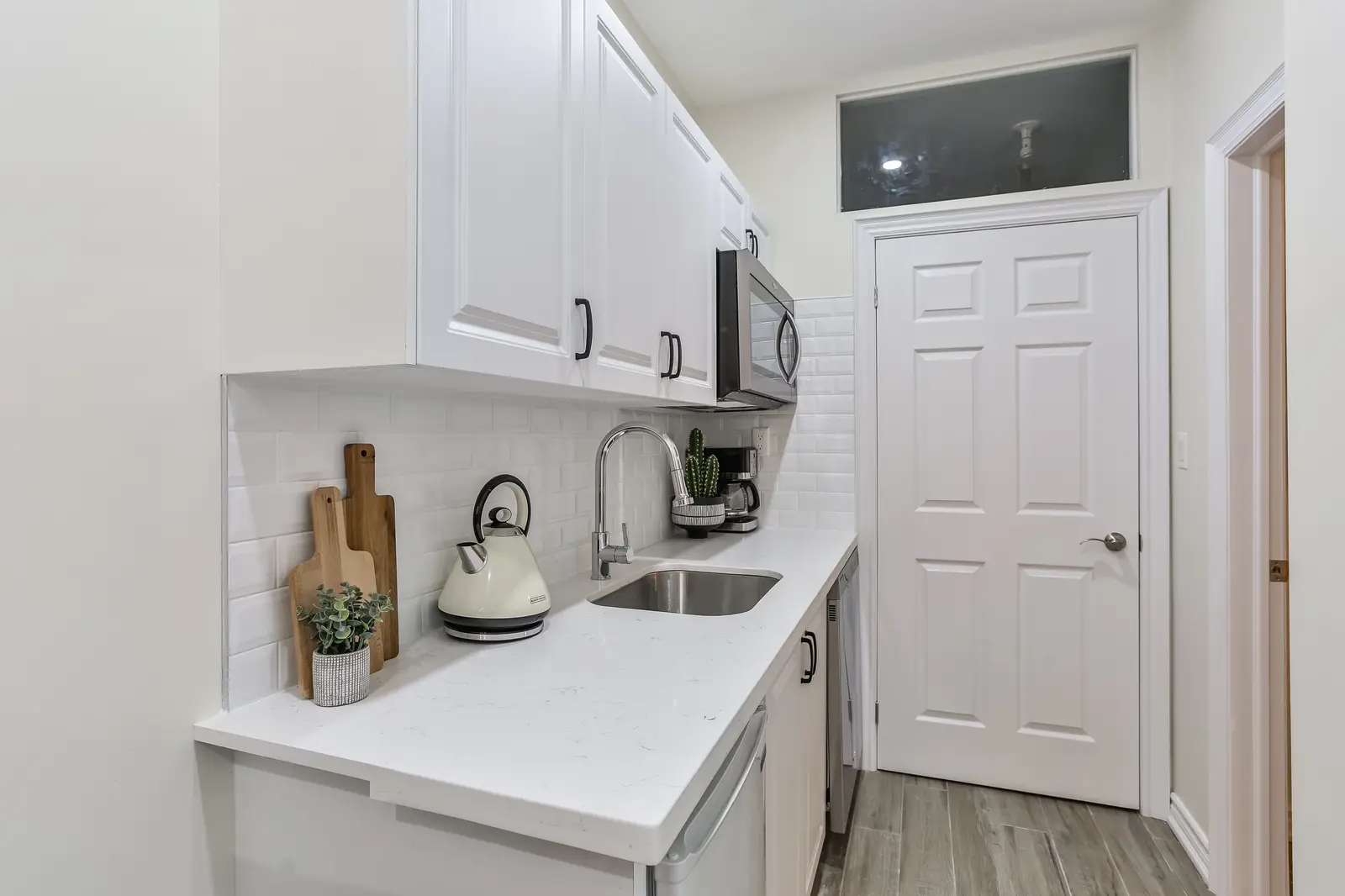 Finished room in a downtown Toronto basement renovation, with white walls, light wood floors, and grey upholstery.