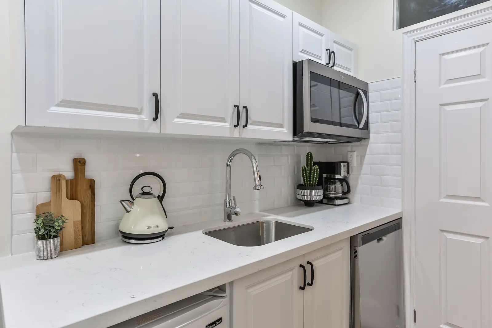 Finished room in a downtown Toronto basement renovation, with white walls, light wood floors, and grey upholstery.