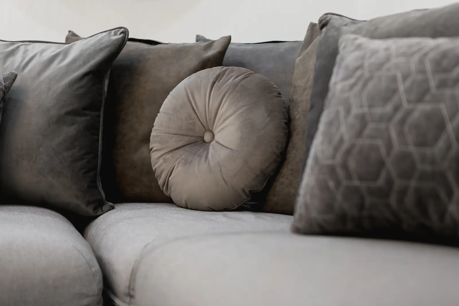 Finished room in a downtown Toronto basement renovation, with white walls, light wood floors, and grey upholstery.