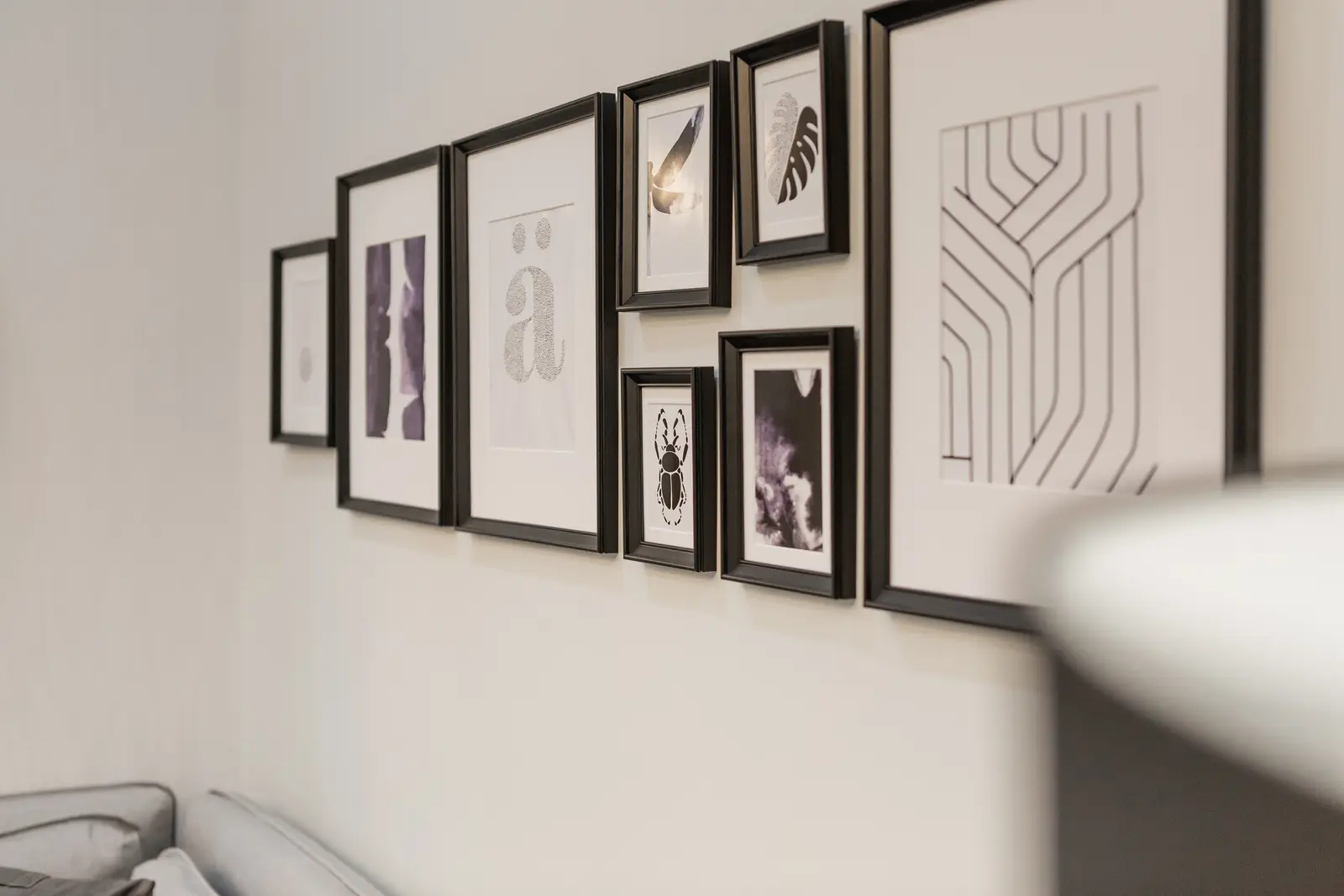 Finished room in a downtown Toronto basement renovation, with white walls, light wood floors, and grey upholstery.