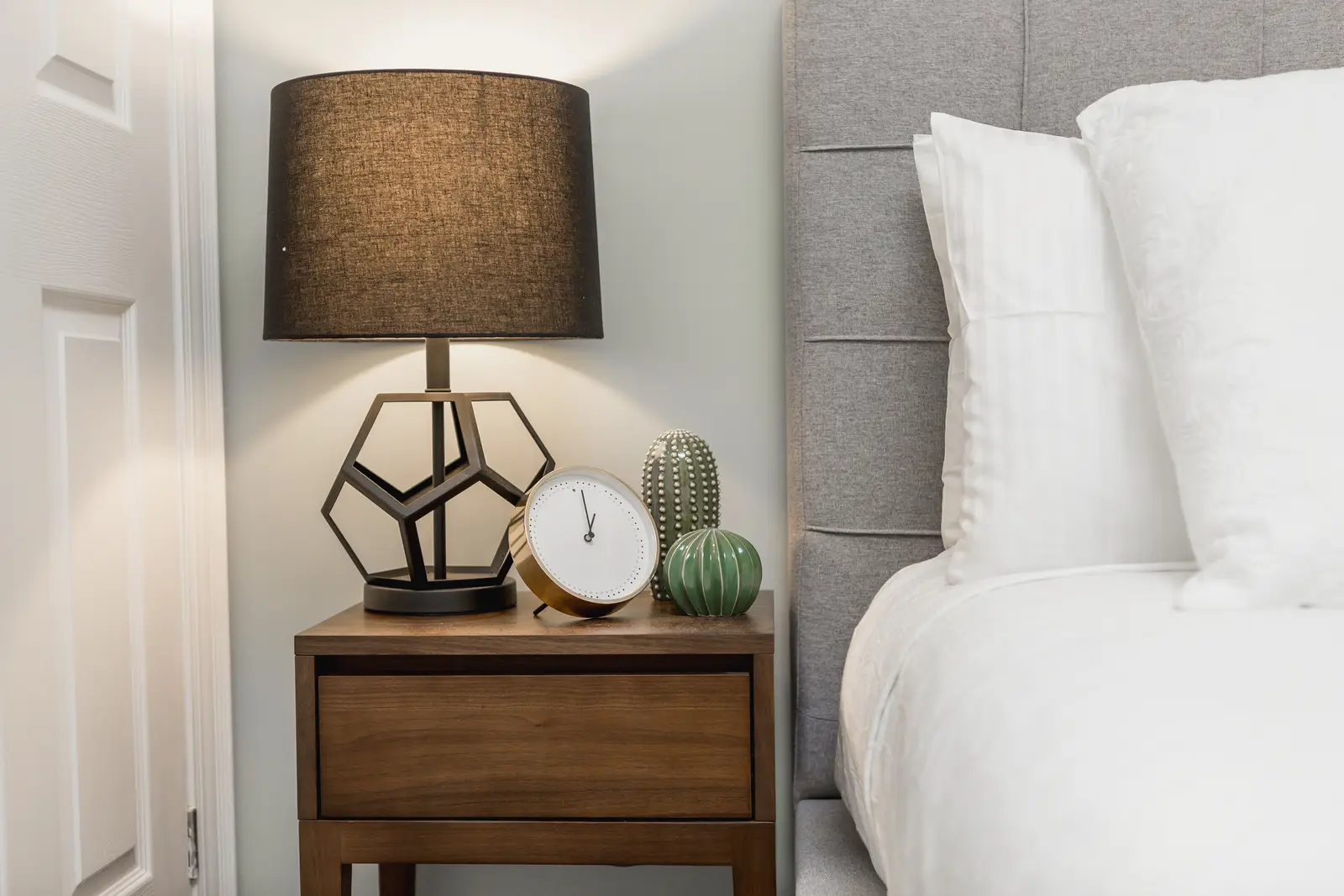 Finished room in a downtown Toronto basement renovation, with white walls, light wood floors, and grey upholstery.
