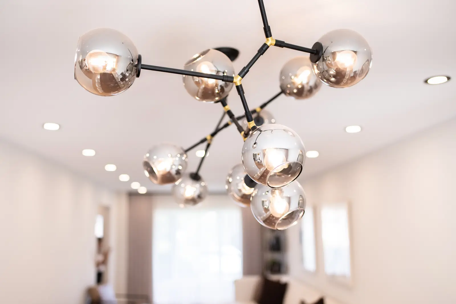 Interior of a Thornhill house renovation, with sage cabinetry, light wood floors, walnut, and brass fittings.