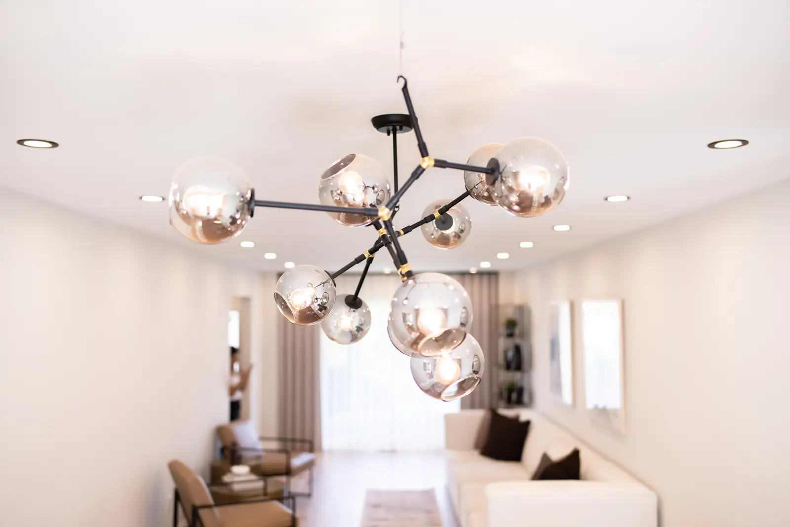 Interior of a Thornhill house renovation, with sage cabinetry, light wood floors, walnut, and brass fittings.