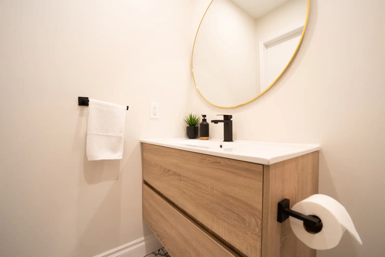 Interior of a Thornhill house renovation, with sage cabinetry, light wood floors, walnut, and brass fittings.