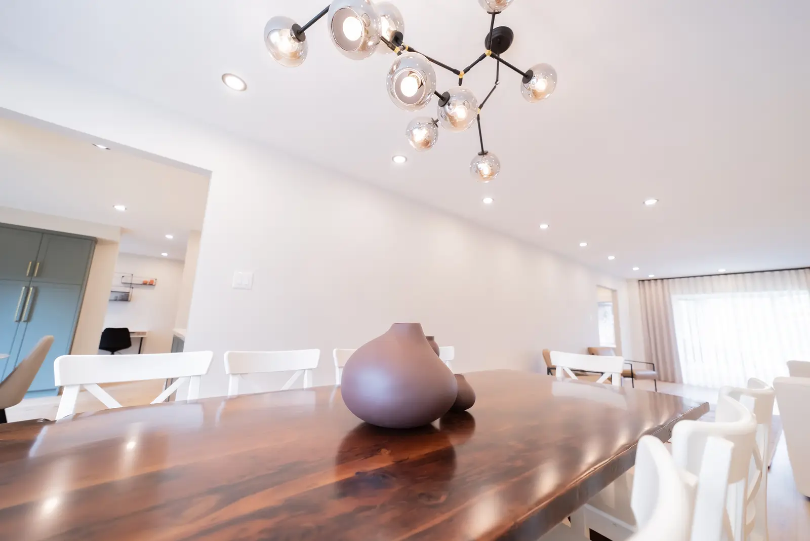 Interior of a Thornhill house renovation, with sage cabinetry, light wood floors, walnut, and brass fittings.