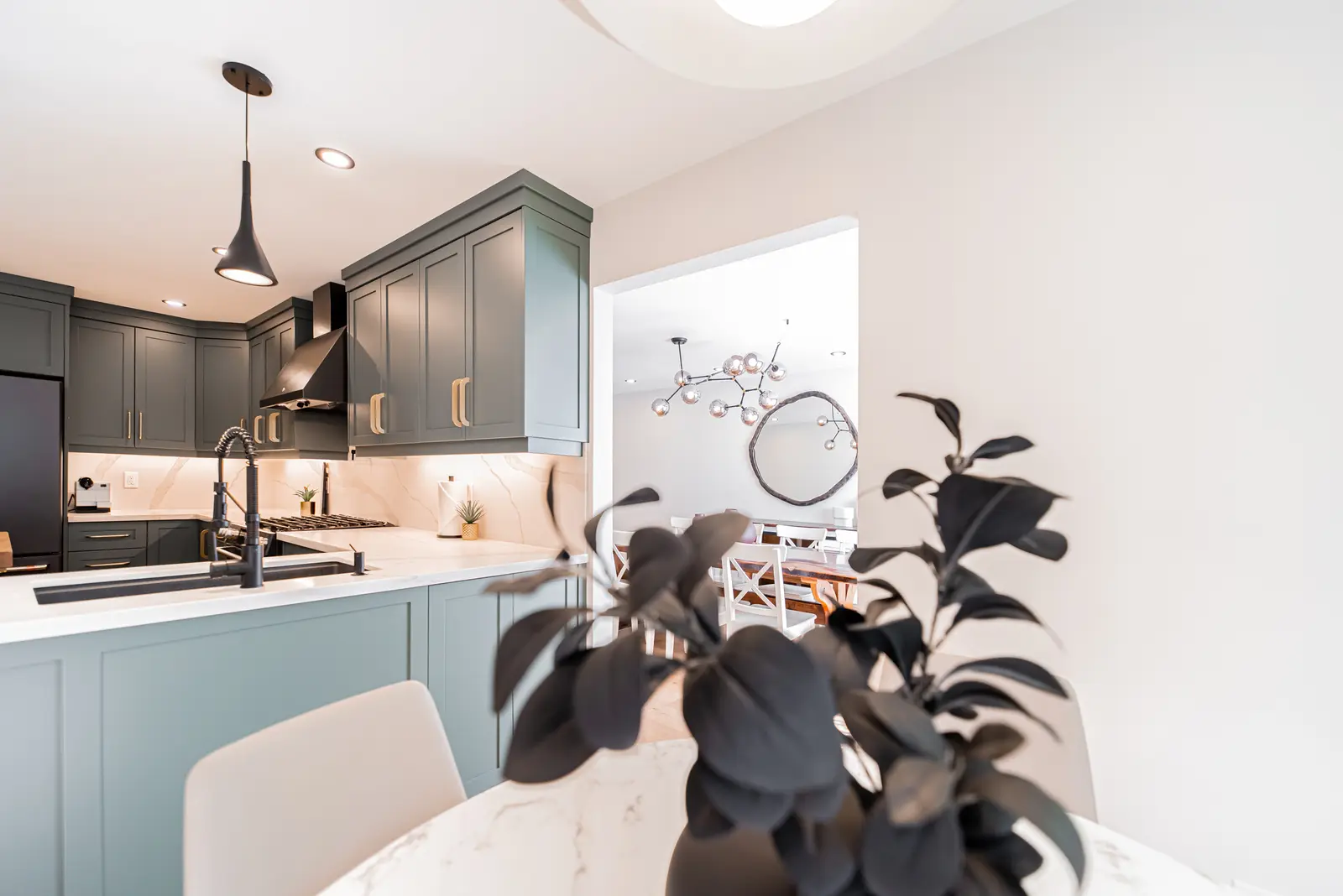 Interior of a Thornhill house renovation, with sage cabinetry, light wood floors, walnut, and brass fittings.