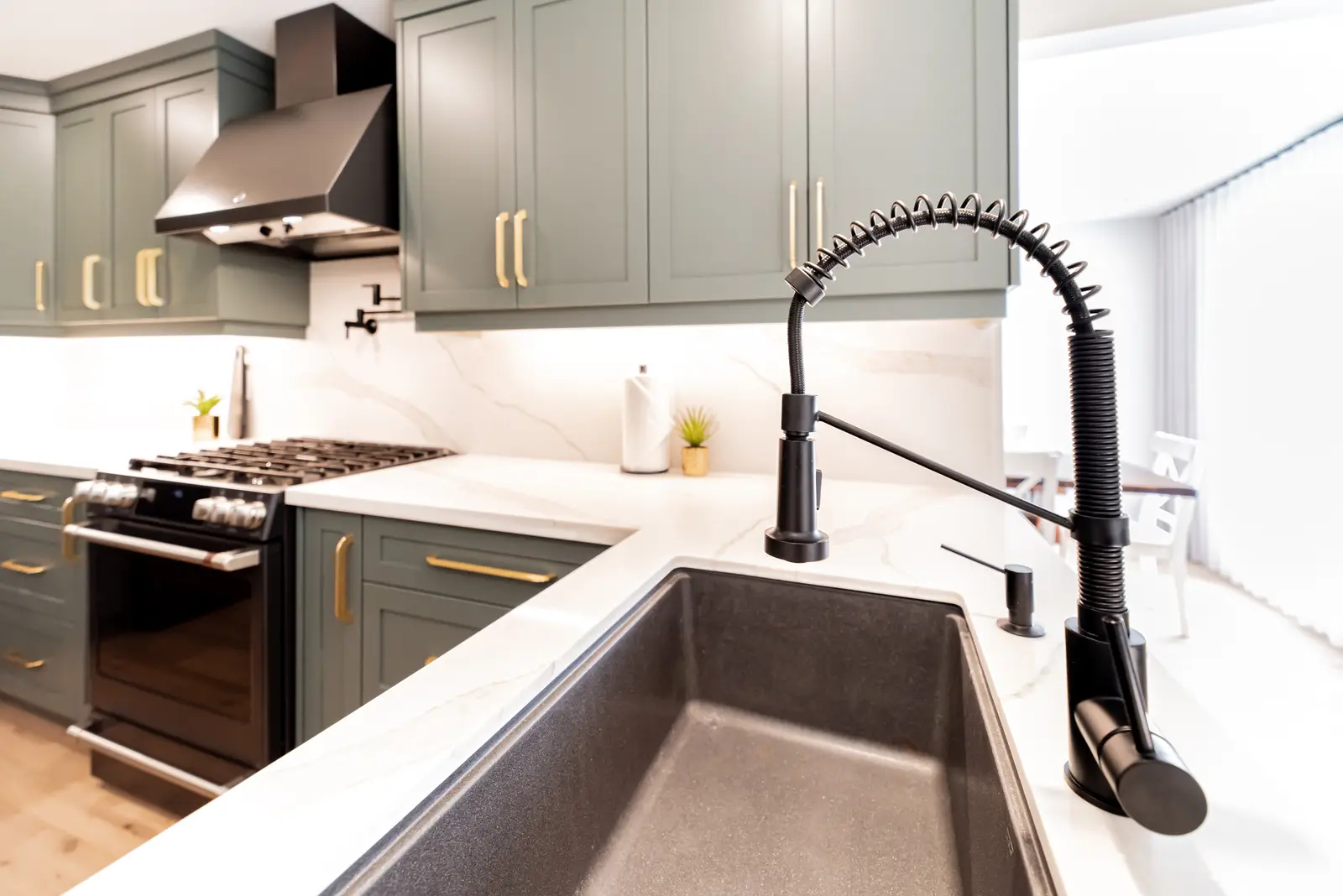 Interior of a Thornhill house renovation, with sage cabinetry, light wood floors, walnut, and brass fittings.