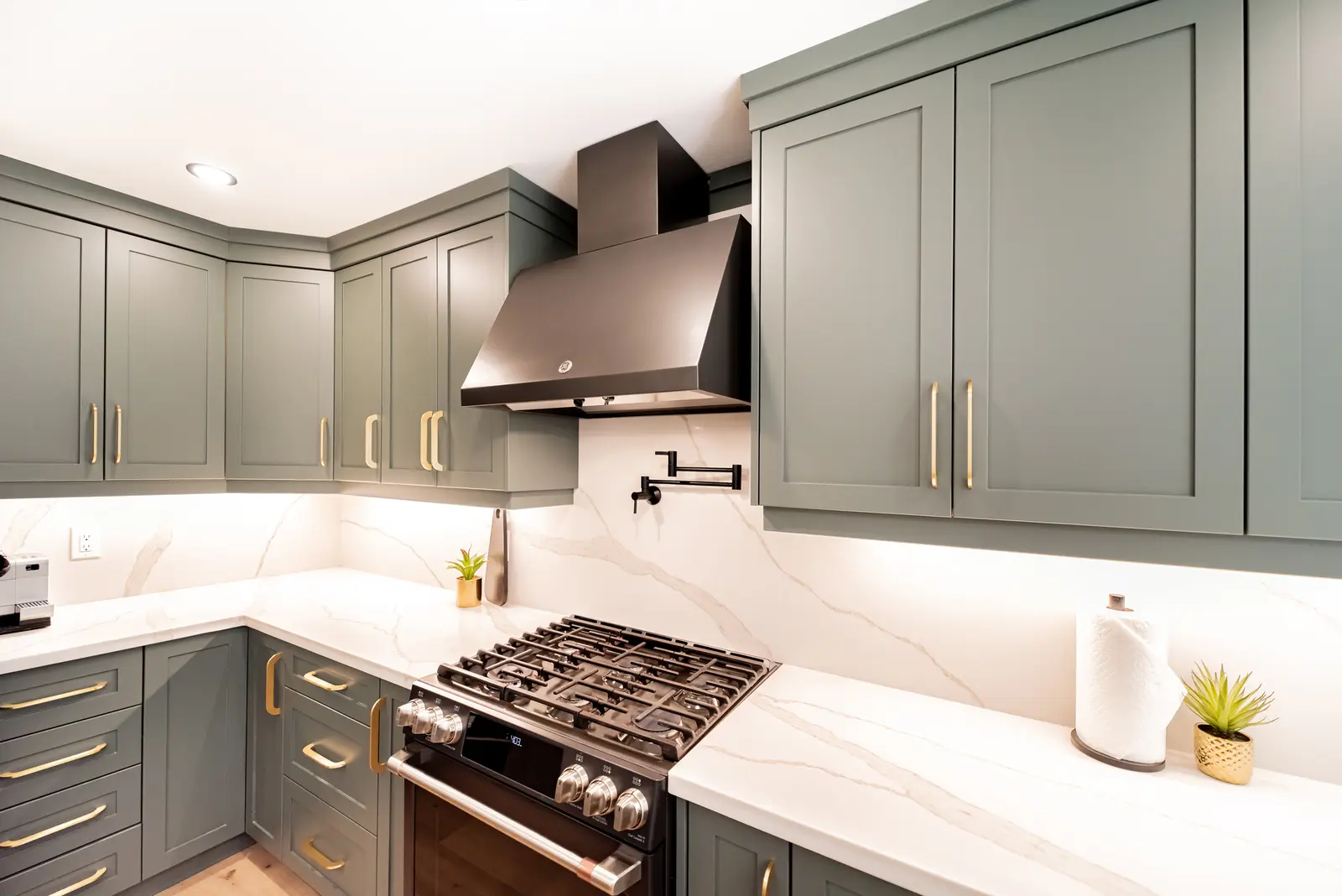 Interior of a Thornhill house renovation, with sage cabinetry, light wood floors, walnut, and brass fittings.