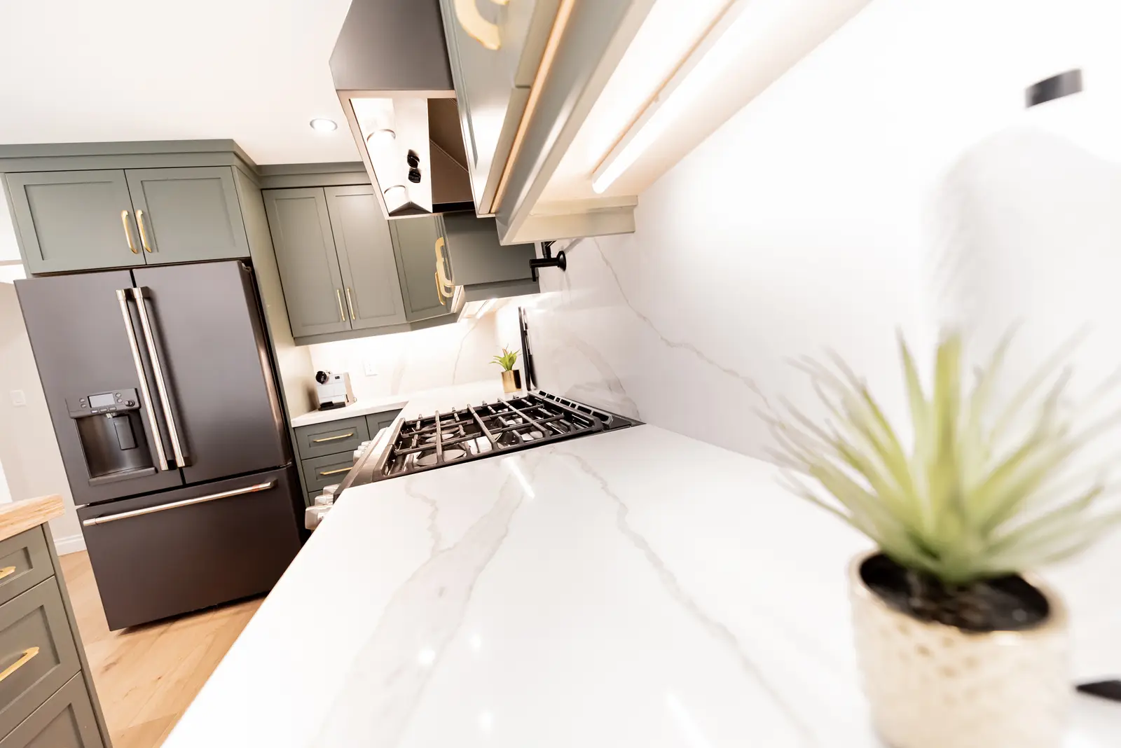 Interior of a Thornhill house renovation, with sage cabinetry, light wood floors, walnut, and brass fittings.
