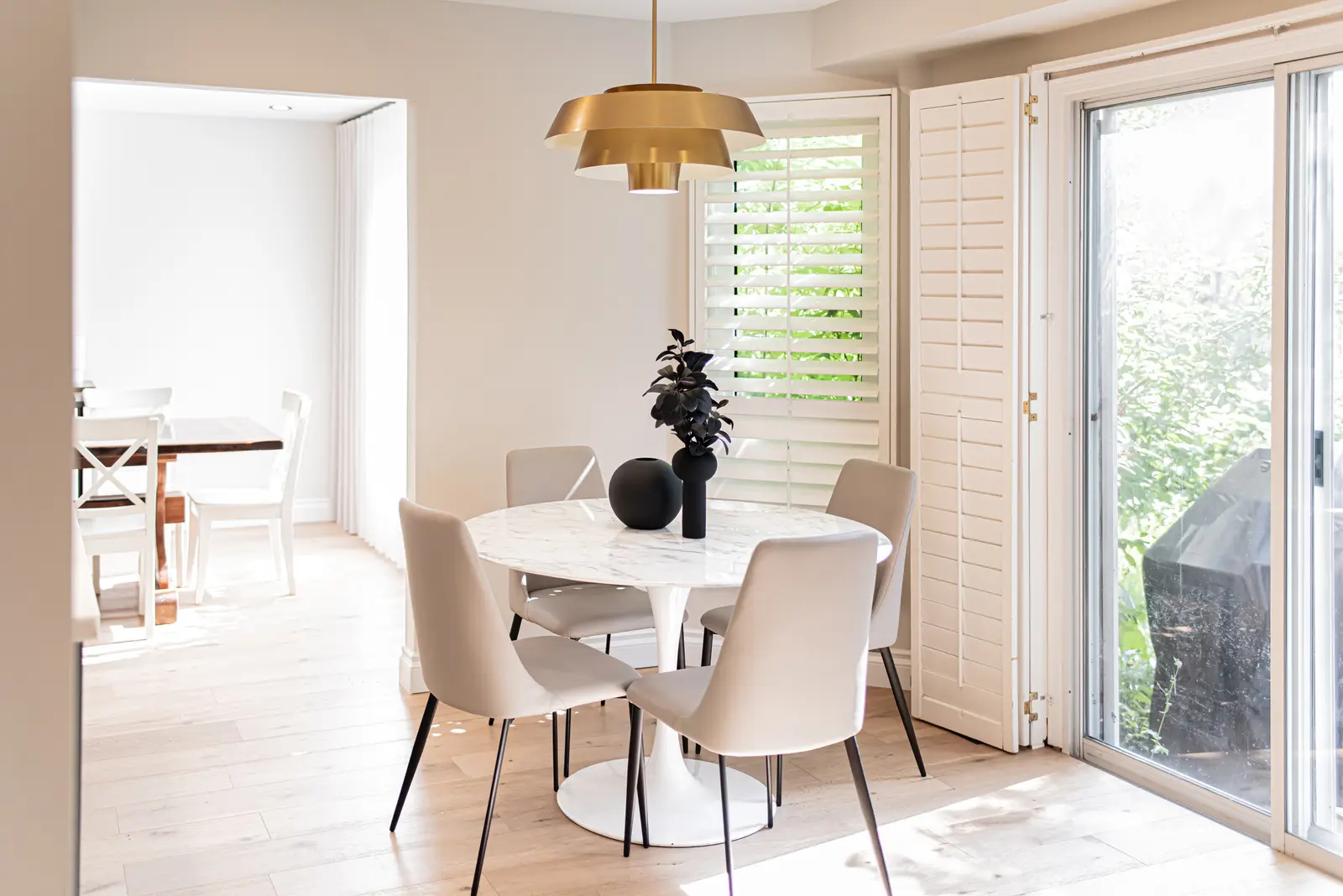 Interior of a Thornhill house renovation, with sage cabinetry, light wood floors, walnut, and brass fittings.