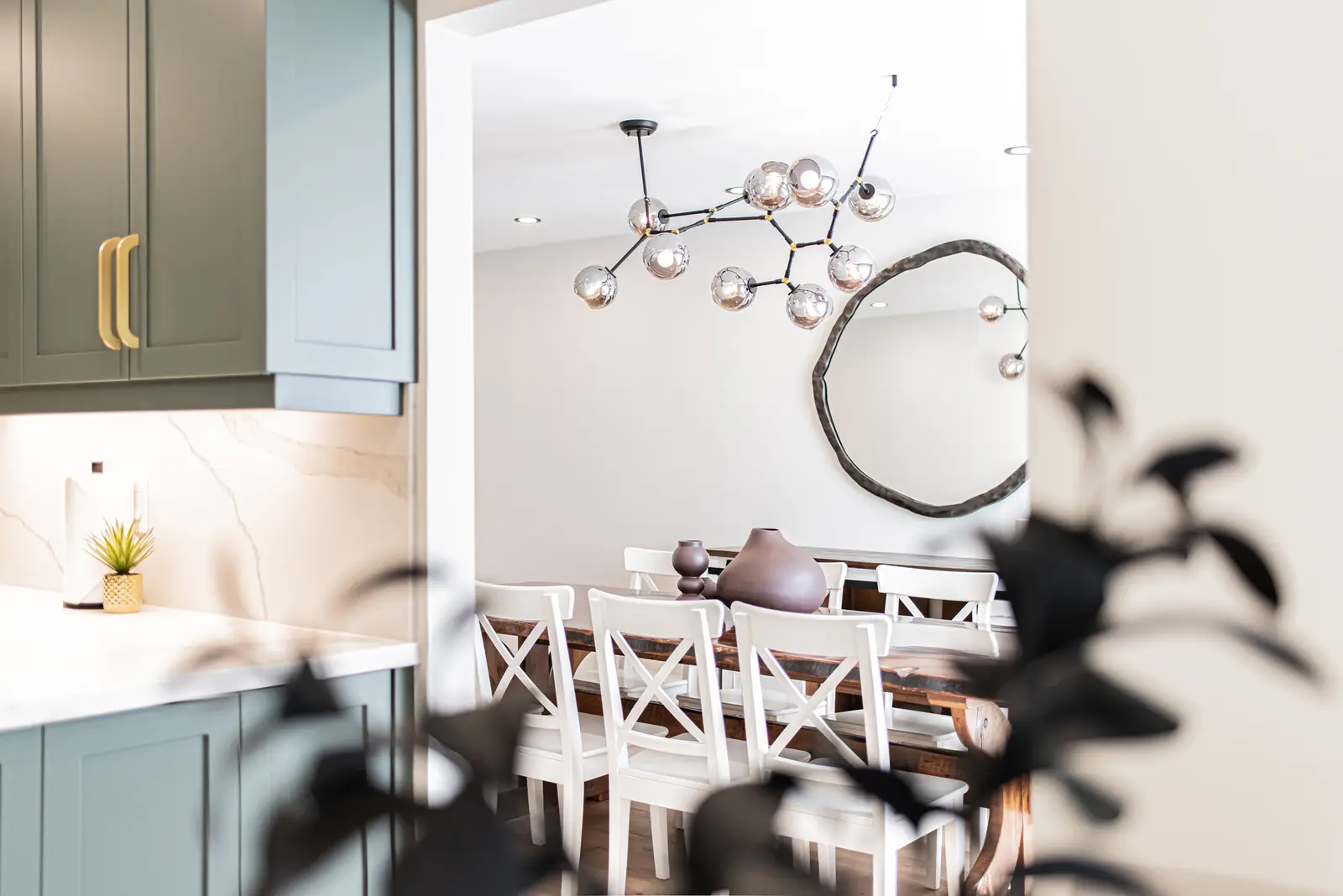 Interior of a Thornhill house renovation, with sage cabinetry, light wood floors, walnut, and brass fittings.