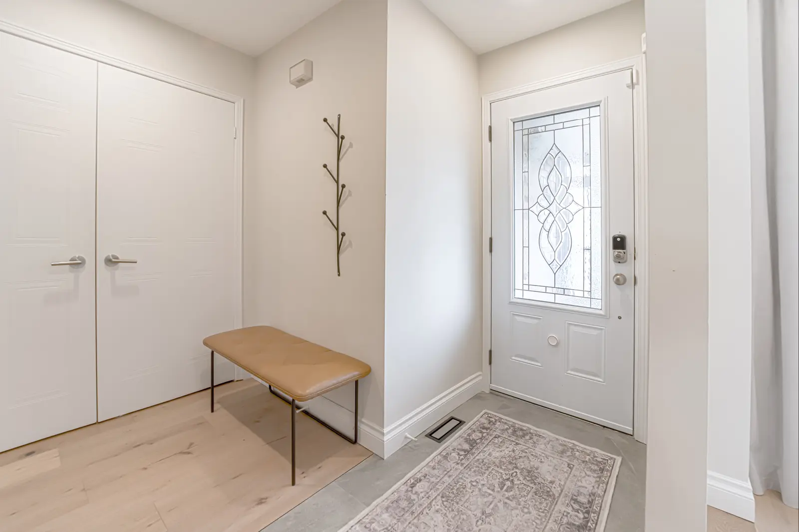 Interior of a Thornhill house renovation, with sage cabinetry, light wood floors, walnut, and brass fittings.