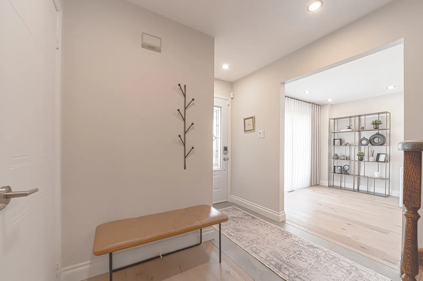 Interior of a Thornhill house renovation, with sage cabinetry, light wood floors, walnut, and brass fittings.