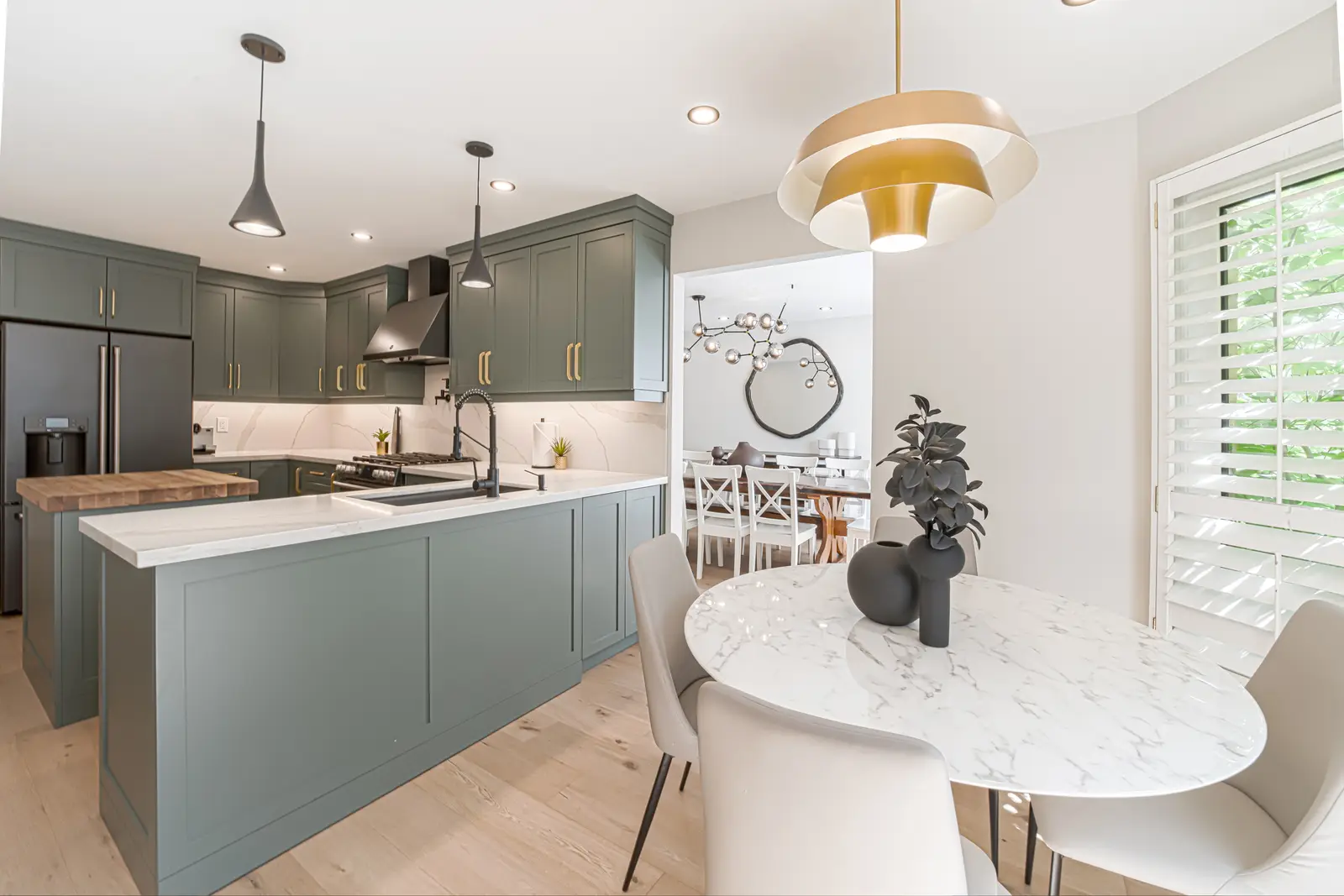 Interior of a Thornhill house renovation, with sage cabinetry, light wood floors, walnut, and brass fittings.