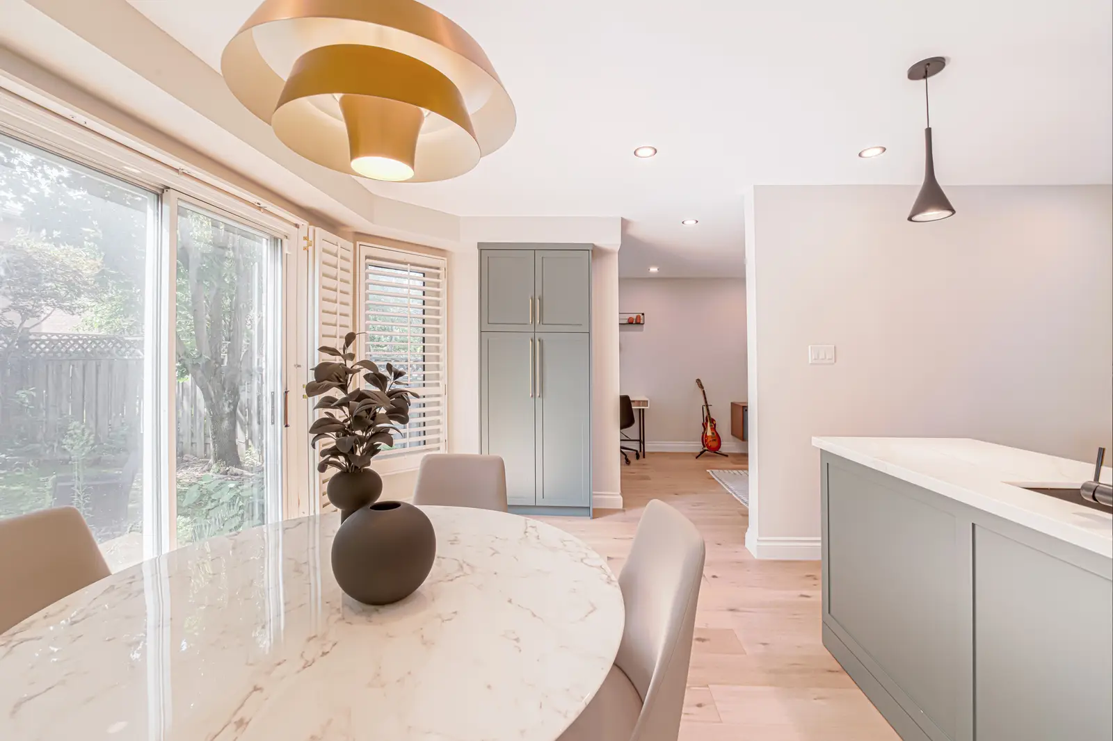 Interior of a Thornhill house renovation, with sage cabinetry, light wood floors, walnut, and brass fittings.