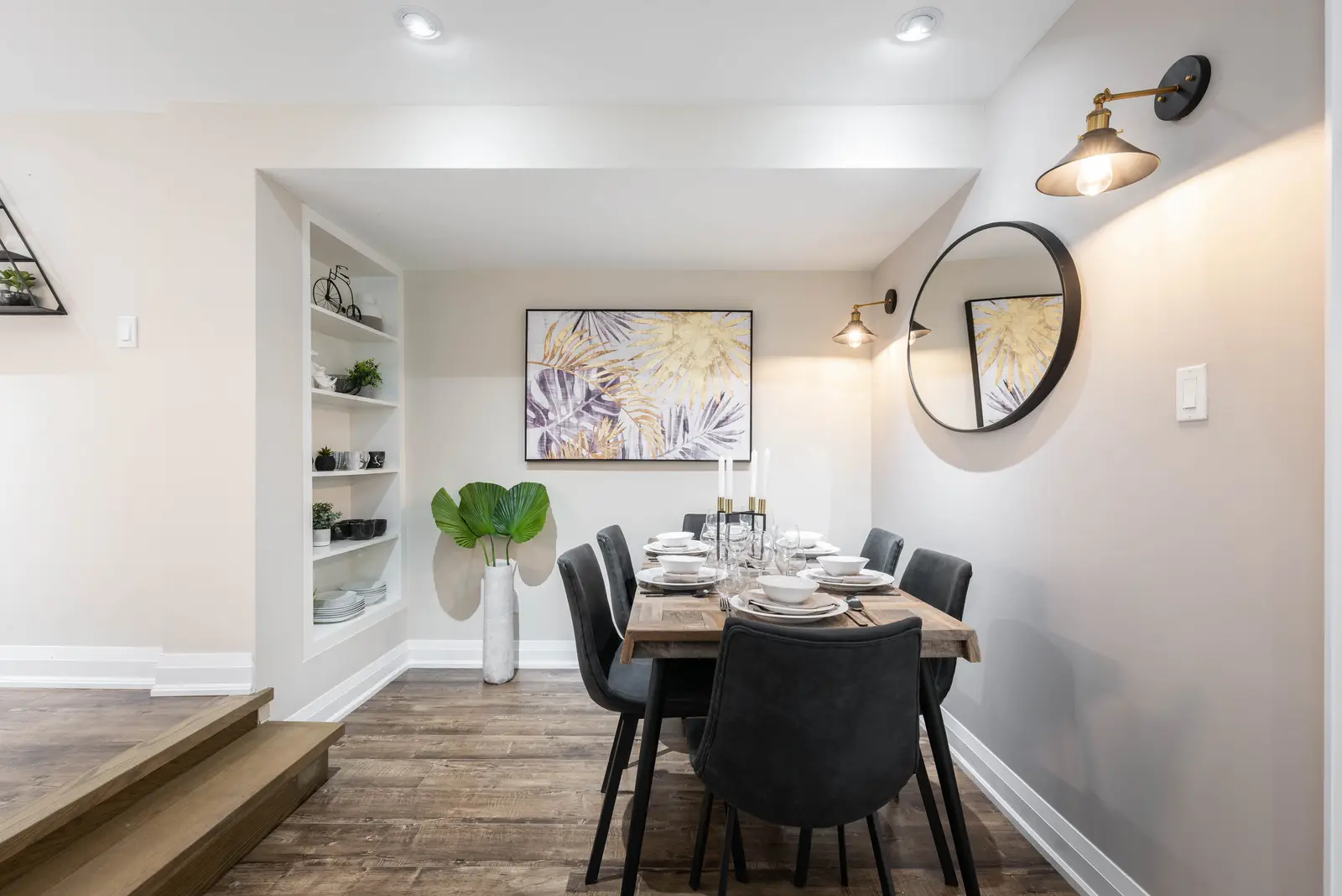 Interior of the house at 309 Manning Avenue in Toronto, with grey chairs, a painted brick wall, and dark wood floors.