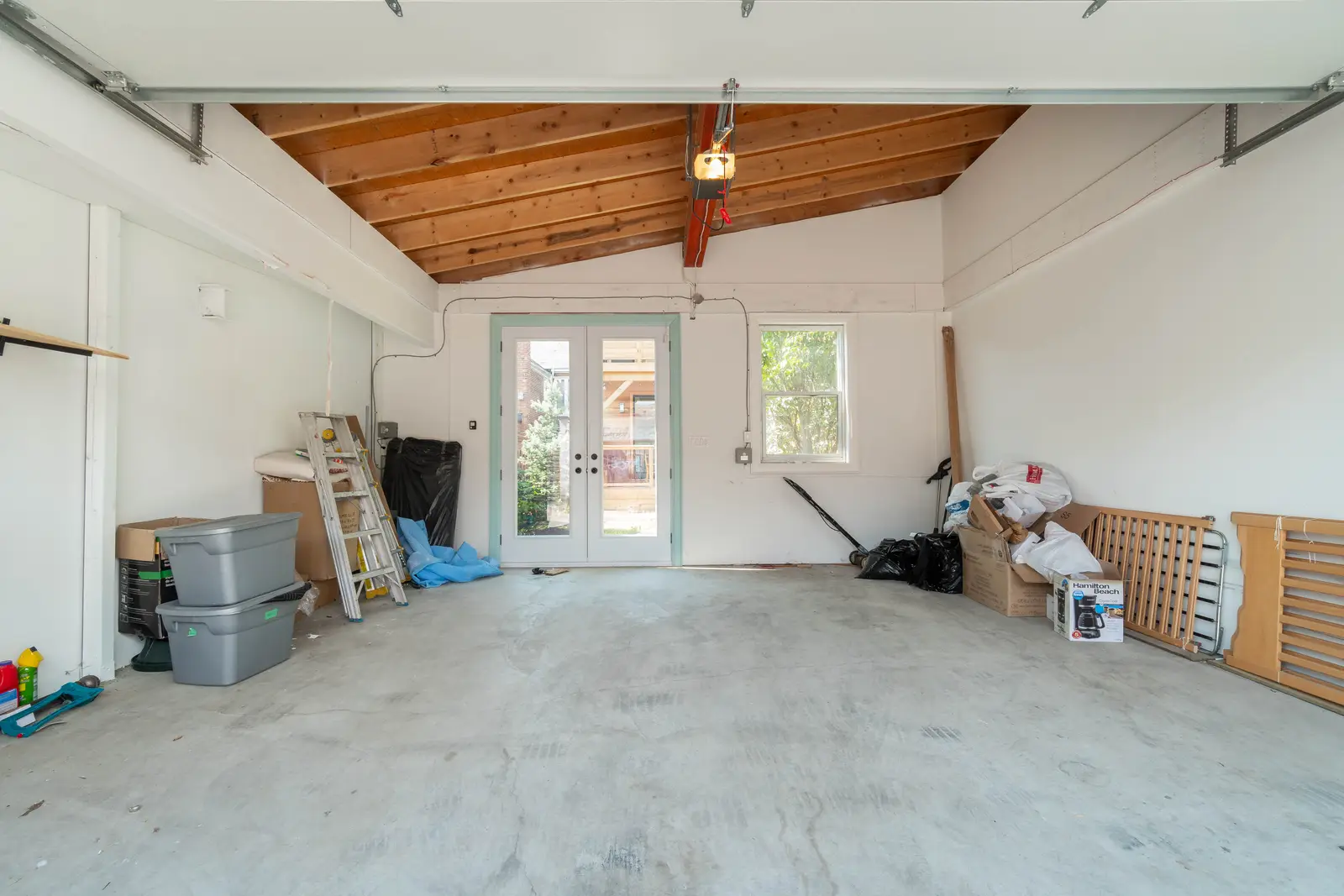 Interior of the house at 309 Manning Avenue in Toronto, with grey chairs, a painted brick wall, and dark wood floors.