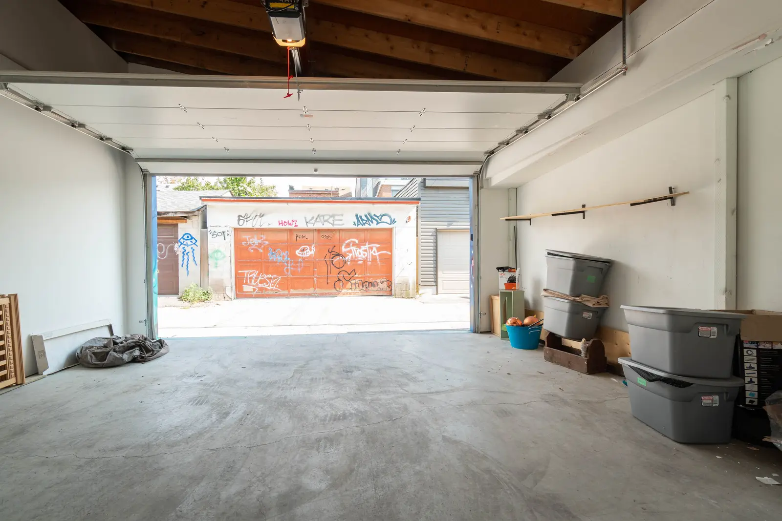 Interior of the house at 309 Manning Avenue in Toronto, with grey chairs, a painted brick wall, and dark wood floors.