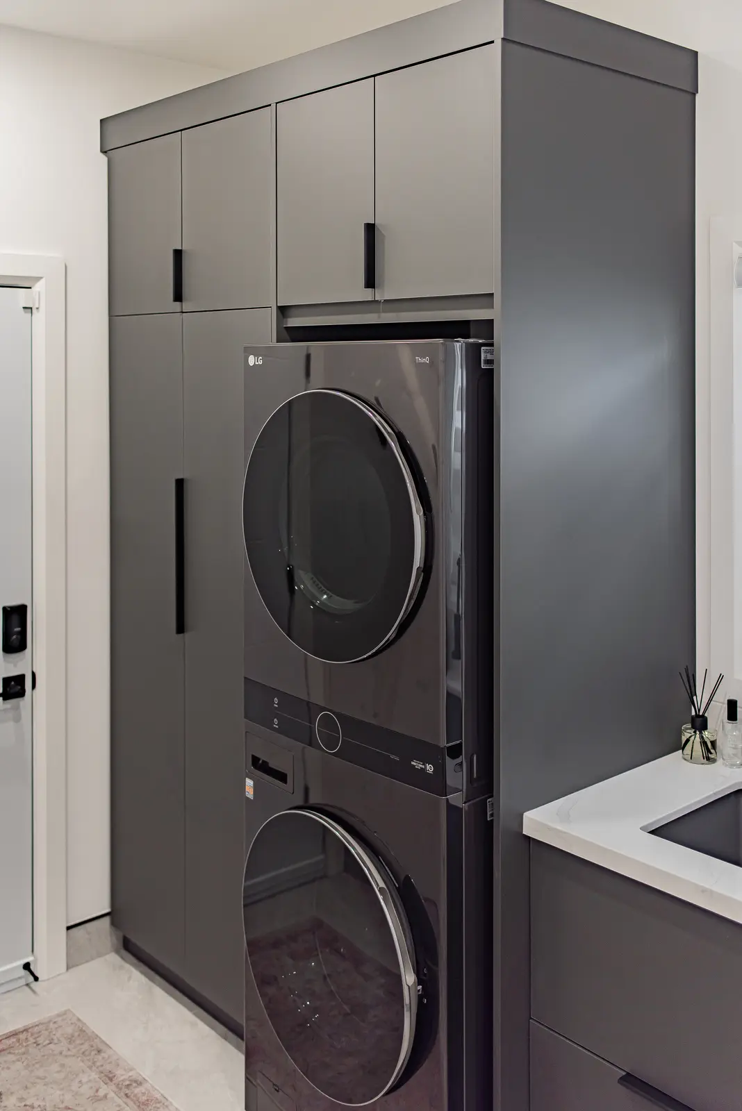 Interior of a Thornhill house renovation, with pale walls, a veined stone kitchen, light wood floors, and black fittings.