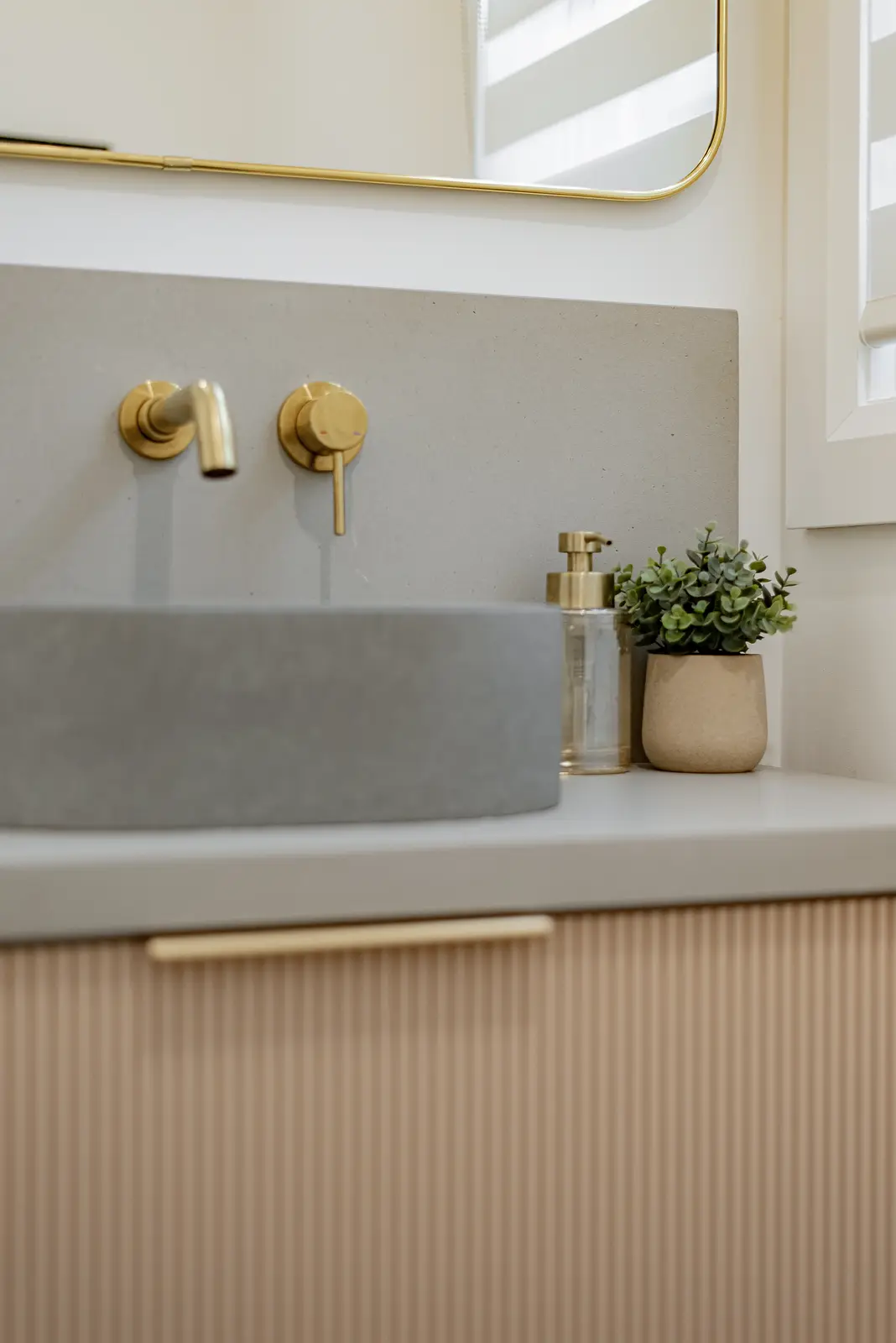 Interior of a Thornhill house renovation, with pale walls, a veined stone kitchen, light wood floors, and black fittings.