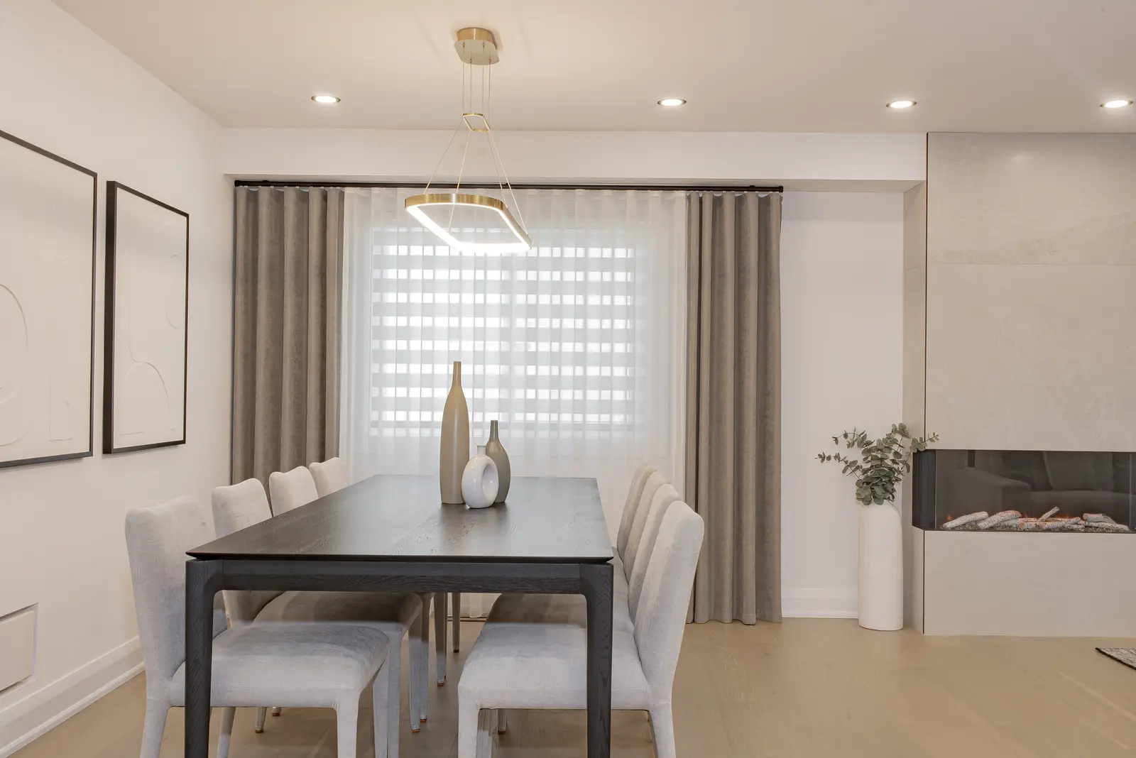 Interior of a Thornhill house renovation, with pale walls, a veined stone kitchen, light wood floors, and black fittings.