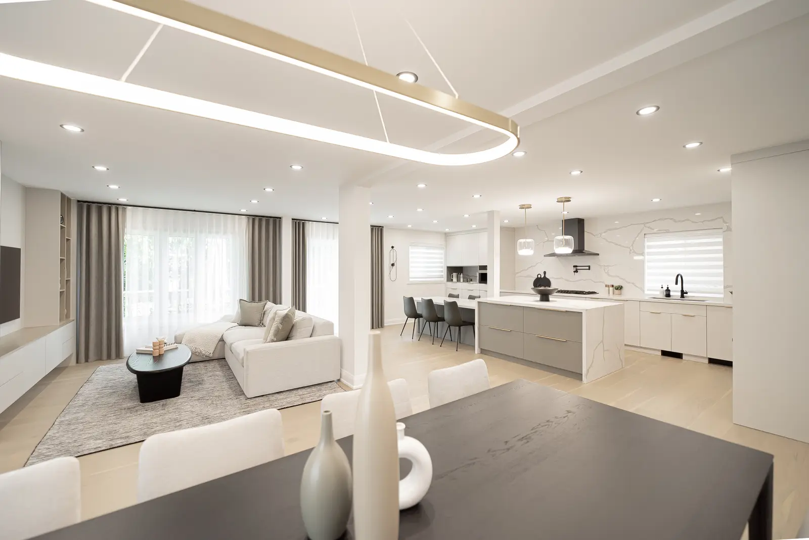 Interior of a Thornhill house renovation, with pale walls, a veined stone kitchen, light wood floors, and black fittings.
