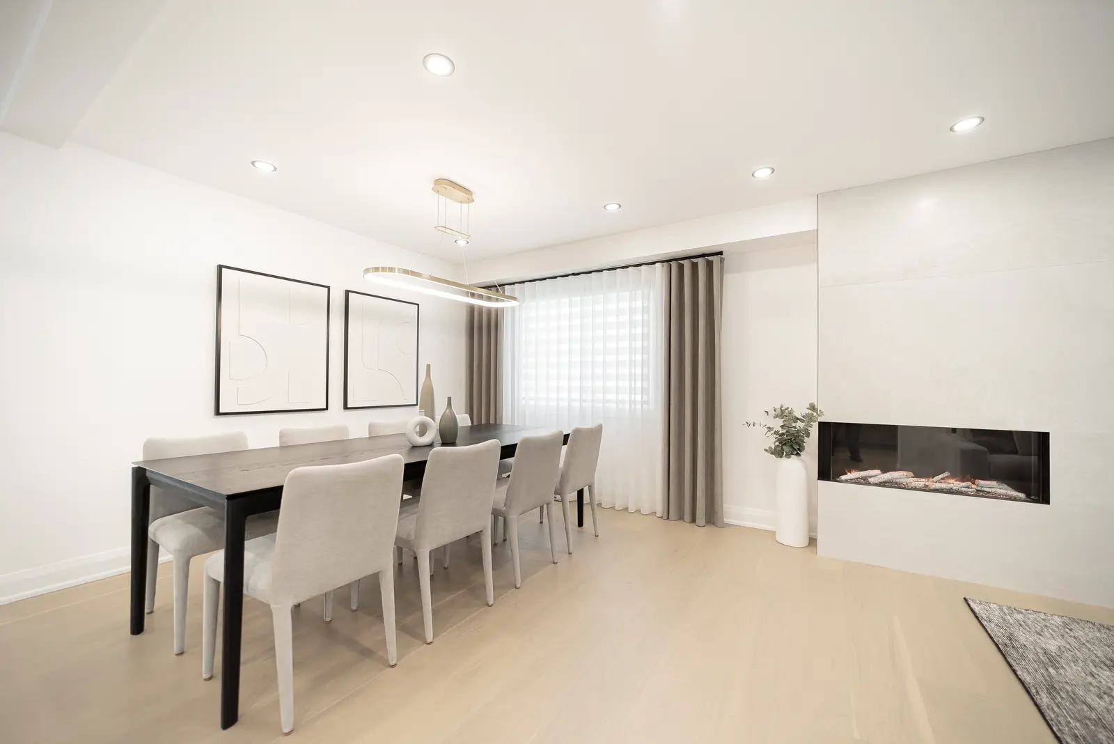 Interior of a Thornhill house renovation, with pale walls, a veined stone kitchen, light wood floors, and black fittings.